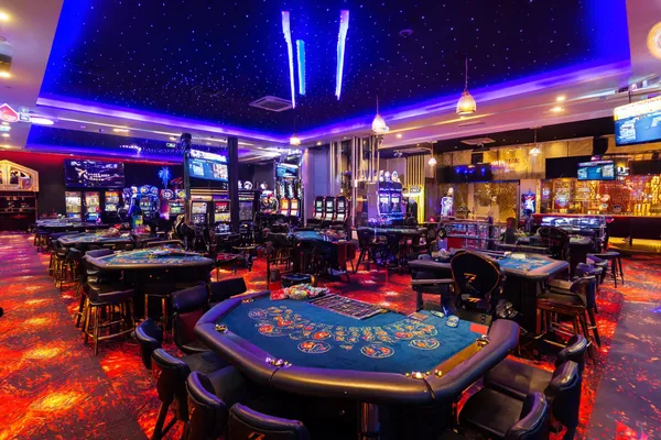 Một người phụ nữ quyến rũ cầm chip casino trong không gian ánh đèn rực rỡ, đại diện cho bầu không khí casino trực tuyến của 789BEF.
